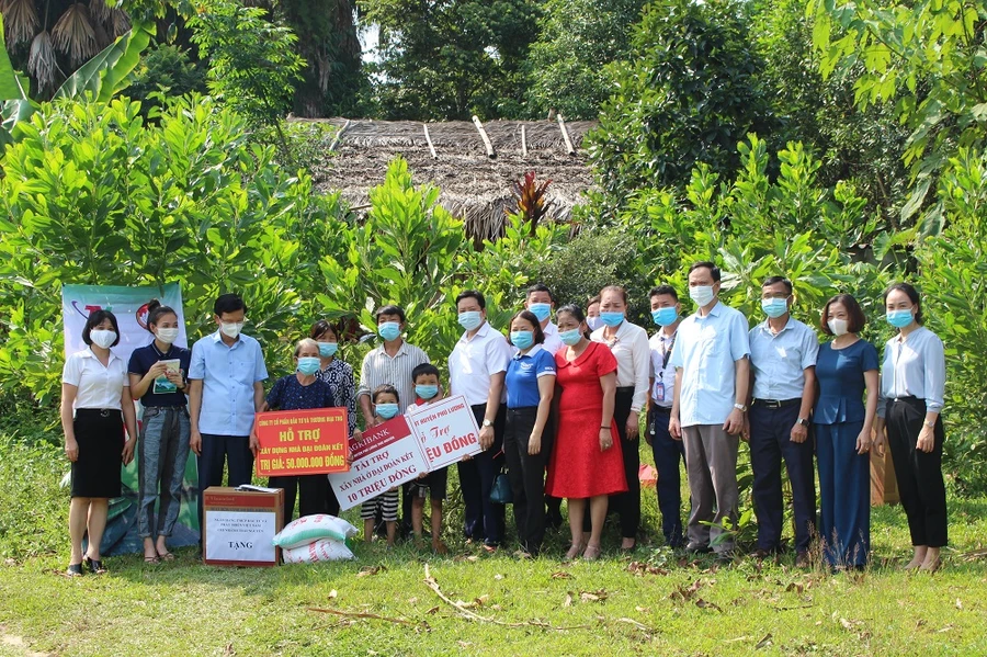 Các đại biểu, nhà tài trợ trao tiền và quà hỗ trợ gia đình bà Hoàng Thị Eng để xây nhà đại đoàn kết.