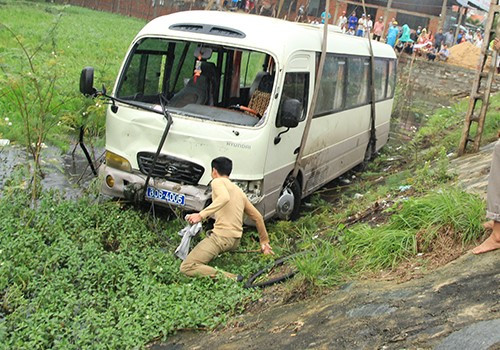 Sau khi người thanh niên này lao xuống dùng vải che biển số, hai người khác cùng lội xuống ao nước để tháo biển số. Ảnh: Nguyễn Đông. 2-8273-1417510027.jpg