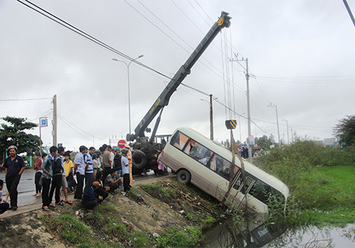 Sau khi lao sang phần đường ngược chiều, chiếc xe biển số xanh cắm phần đầu xuống ao nước. Ảnh: Nguyễn Đông. 1-3666-1417510027.jpg