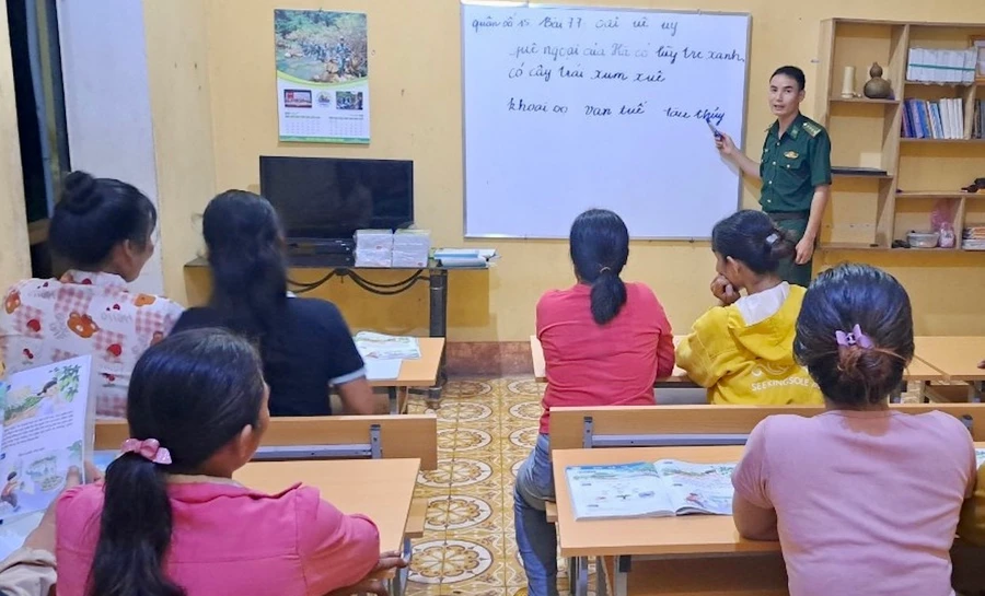 Thầy giáo mang quân hàm xanh Đồn Biên phòng Ia Lốp dạy chữ cho học viên khu dân cư suối Khôn.