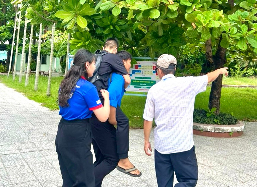 Lực lượng tình nguyện viên tại điểm thi Trường THPT Nguyễn Hiền hỗ trợ thí sinh di chuyển vào phòng thi.