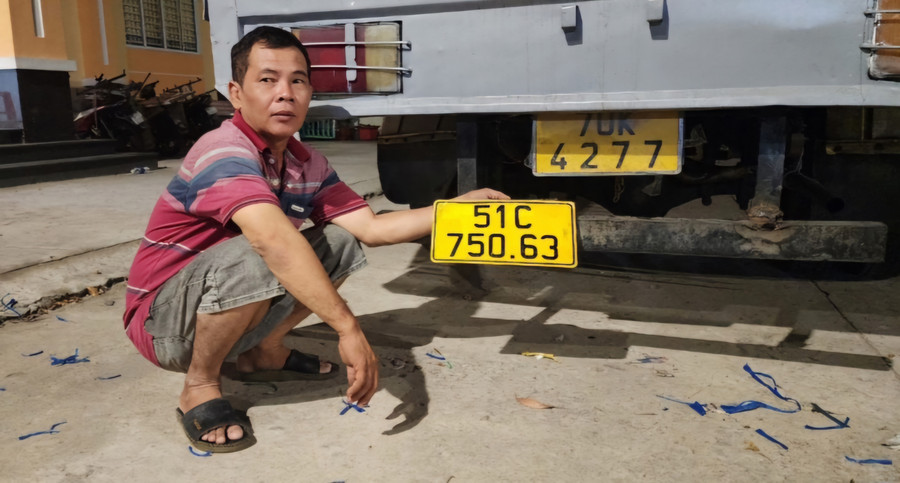 Người đàn ông thay biển kiểm soát ô tô giả nhằm ngụy trang. (Ảnh: Văn Vũ).