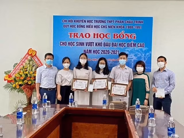 Ban giám hiệu Trường THPT Phan Châu Trinh trao học bổng cho những học sinh vượt khó đậu đại học với số điểm cao từ nguồn quỹ học bổng của cựu học sinh.