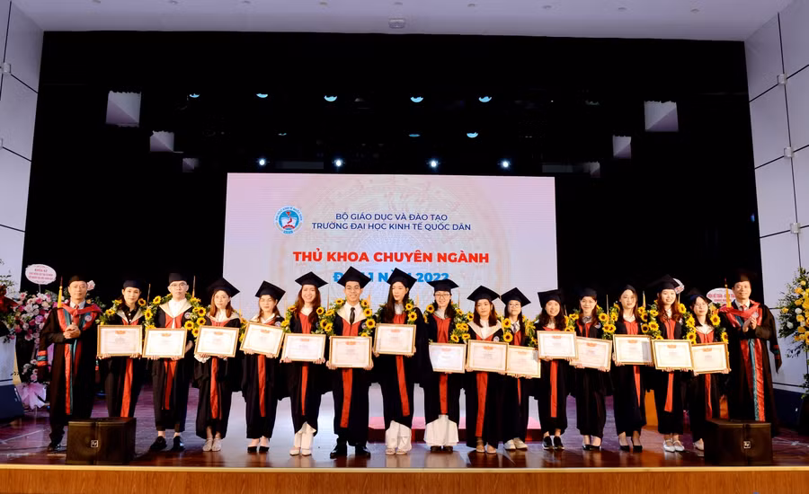 GS.TS Phạm Hồng Chương – Hiệu trưởng nhà trường và PGS.TS Bùi Đức Thọ - Bí thư Đảng ủy, Chủ tịch Hội đồng trường trao giấy khen và tặng hoa cho các tân cử nhân.