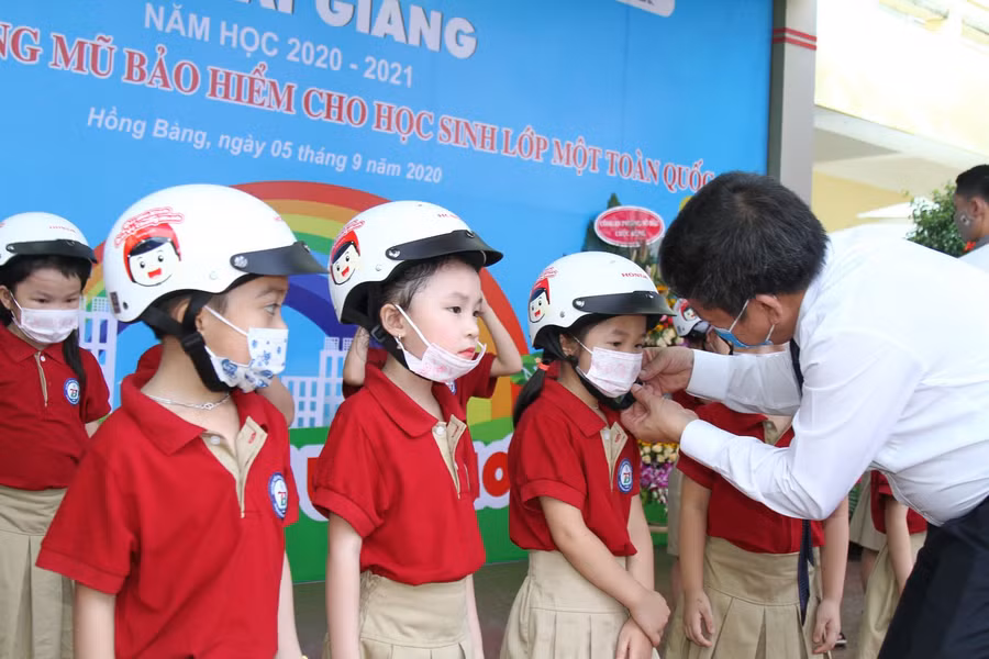 Phó Giám đốc Sở GD&amp;ĐT Vũ văn Trà đeo mũ bảo hiểm cho học sinh