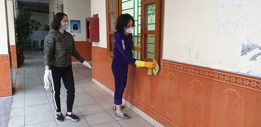 Chị Đinh Thị Hương, phụ huynh học sinh lớp 1 A9 (áo xám) cùng cô giáo chủ nhiệm Đàm Hải Yến vệ sinh lớp học