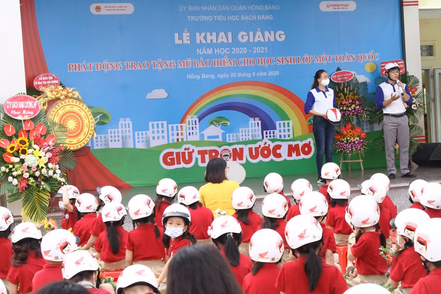 Nhân viên Công ty Hoda Việt Nam hướng dẫn học sinh cách đội mũ bảo hiểm