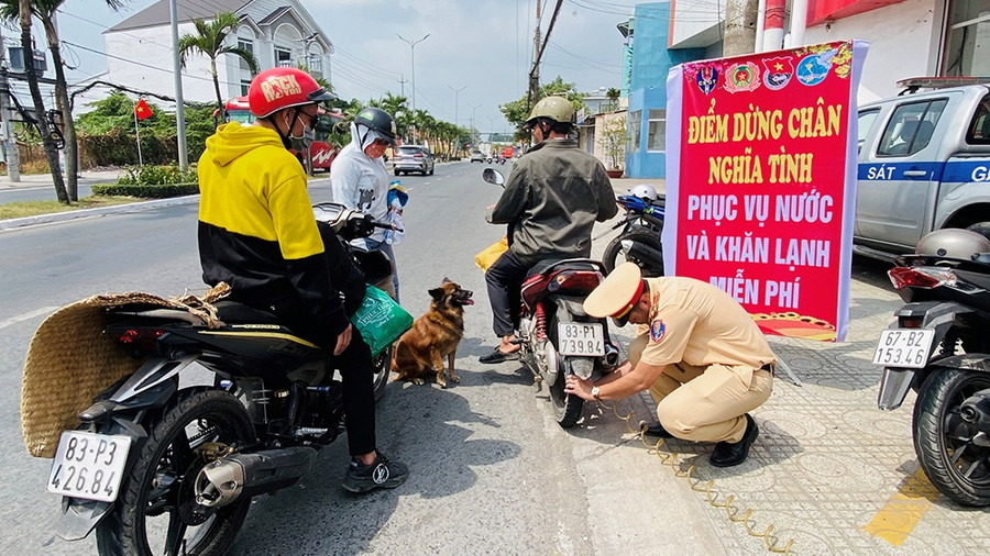 CB, CS Phòng CSGT bơm xe giúp người dân. (Ảnh: Tiến Tầm)