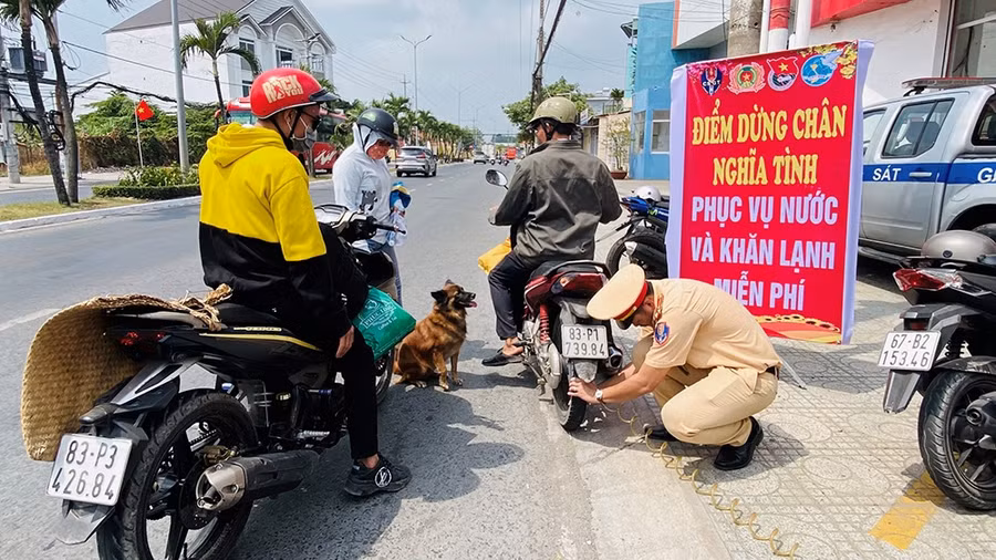 CB, CS Phòng CSGT bơm xe giúp người dân. (Ảnh: Tiến Tầm)