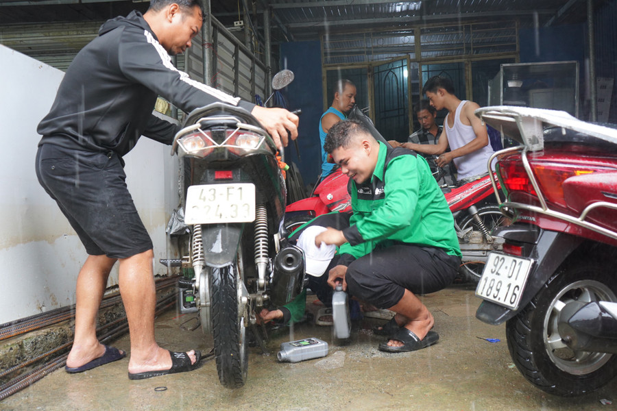 Ngoài sửa những xe bị chết máy, đội SV tình nguyện còn thay nhớt, bugi cho xe.