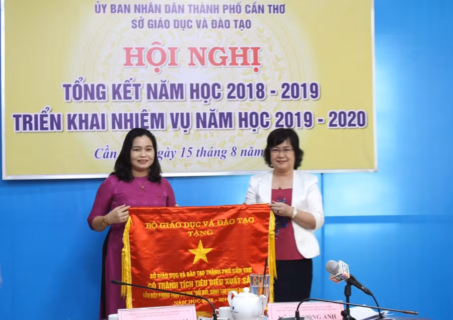 Bà Võ Thị Hồng Ánh (phải) - Phó Chủ tịch UBND TP Cần Thơ trao Cờ thi đua của Bộ GD&ĐT cho ngành GD&ĐT TP Cần Thơ