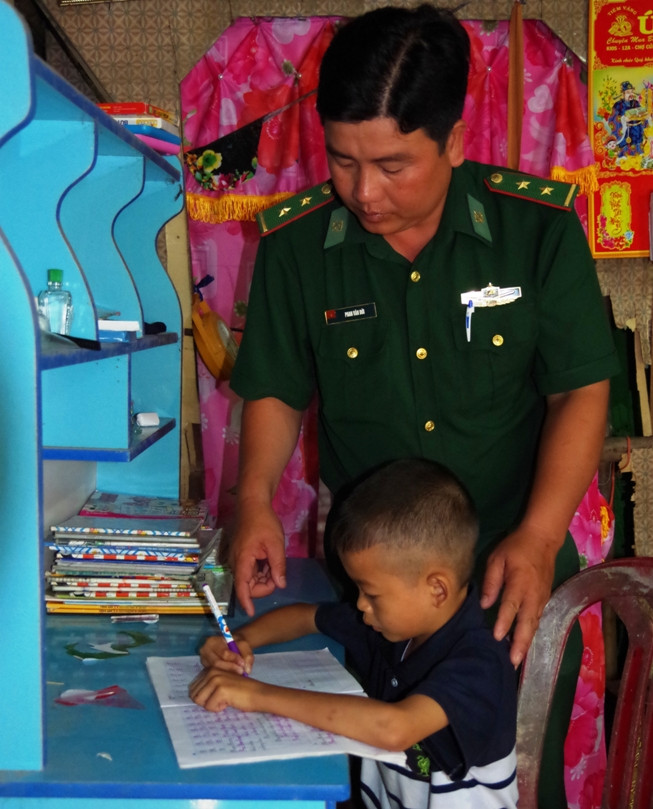 Cán bộ Đội vận động quần chúng, Đồn Biên phòng cửa khẩu quốc tế Dinh Bà, BĐBP Đồng Tháp hướng dẫn HS làm bài tập