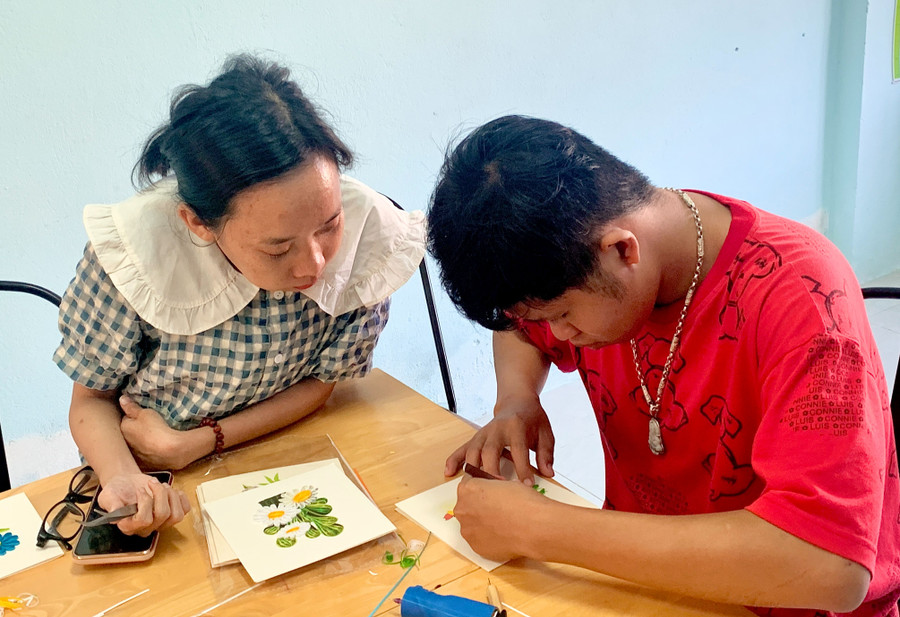 Chị Láng hướng dẫn học viên dán giấy xoắn. Chị Láng hướng dẫn học viên dán giấy xoắn.