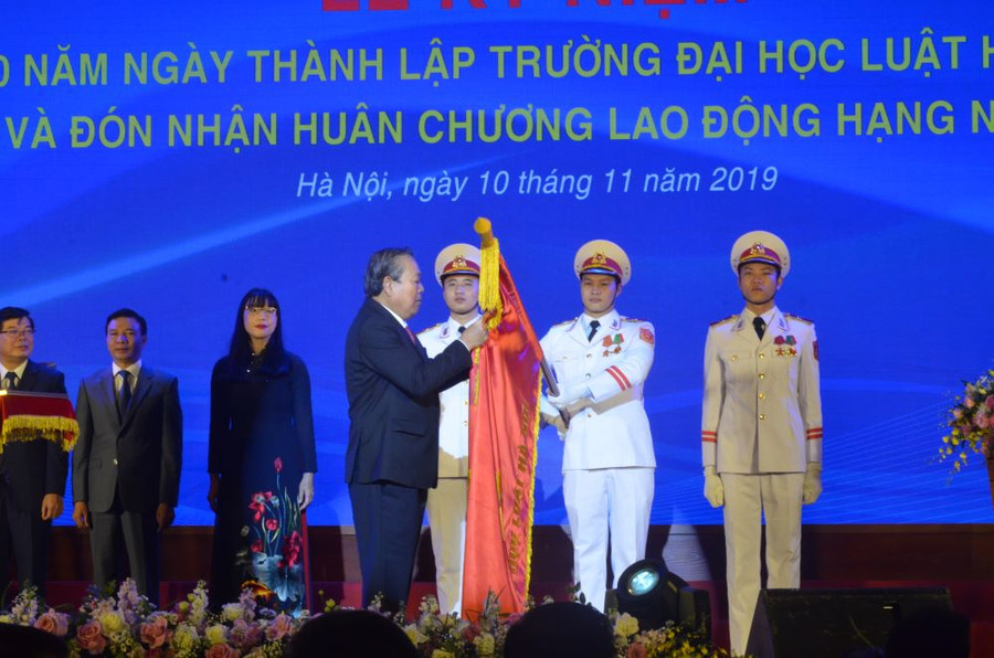 Phó Thủ tướng Chính phủ Trương Hòa Bình gắn Huân chương trong nghi lễ đón nhận Huân chương Lao động hạng nhất của Trường ĐH Luật Hà Nội.