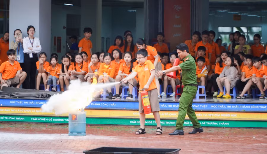 Học sinh Trường Tiểu học & THCS FPT Đà Nẵng được cán bộ công an hướng dẫn cách sử dụng bình chữa cháy mini dập lửa.