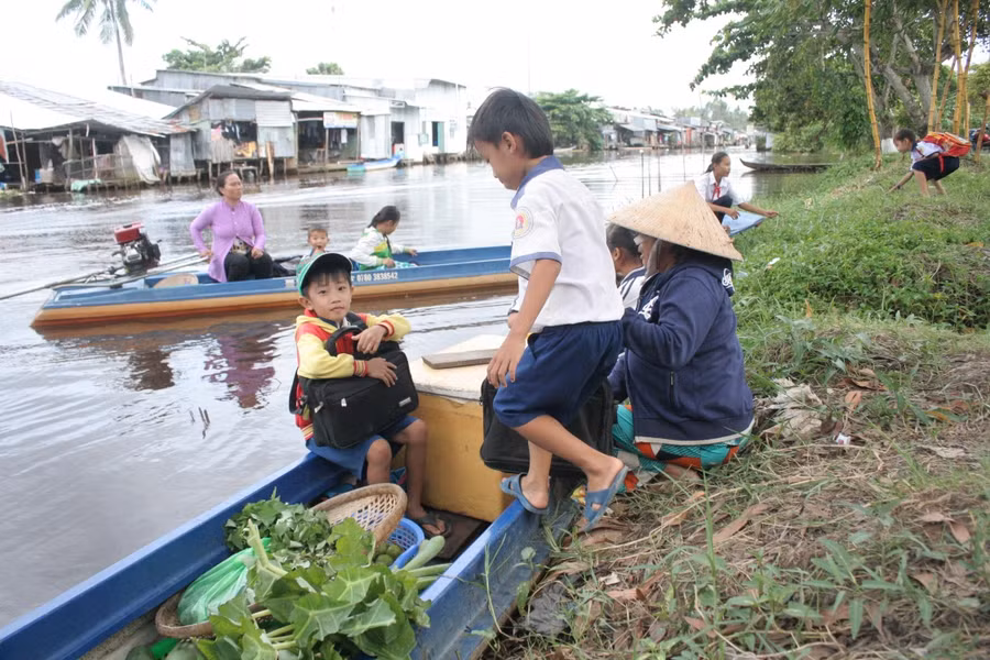 Học sinh vùng sông nước Cà Mau đến trường bằng xuồng. Ảnh: Q. Ngữ.