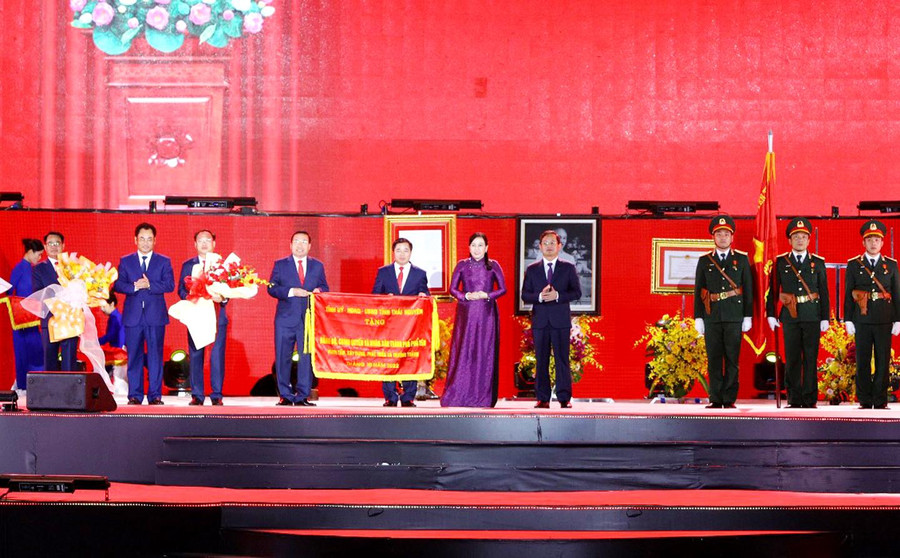 Các đồng chí lãnh đạo tỉnh trao Cờ lưu niệm của Tỉnh ủy, HĐND, UBND tỉnh tặng Đảng bộ, chính quyền và Nhân dân các dân tộc TP. Phổ Yên tại Lễ công bố.