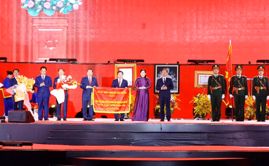 Các đồng chí lãnh đạo tỉnh trao Cờ lưu niệm của Tỉnh ủy, HĐND, UBND tỉnh tặng Đảng bộ, chính quyền và Nhân dân các dân tộc TP. Phổ Yên tại Lễ công bố.