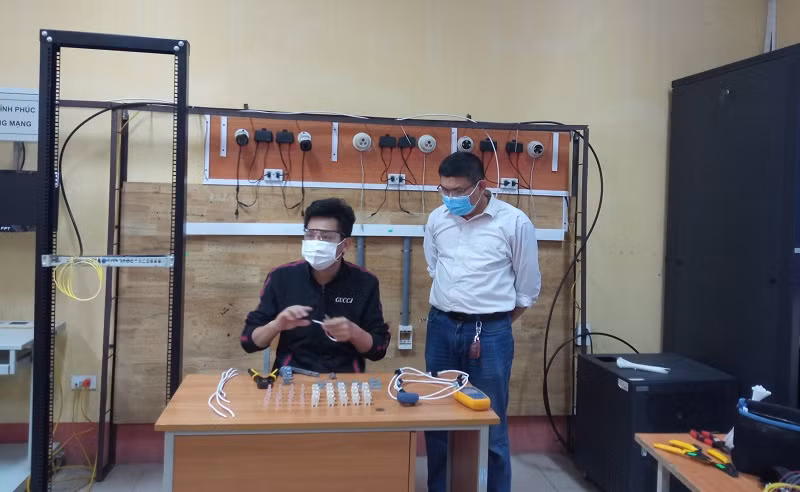 Lương Văn Tiến (bìa trái) cùng thầy giáo hướng dẫn tập luyện trước cuộc thi.