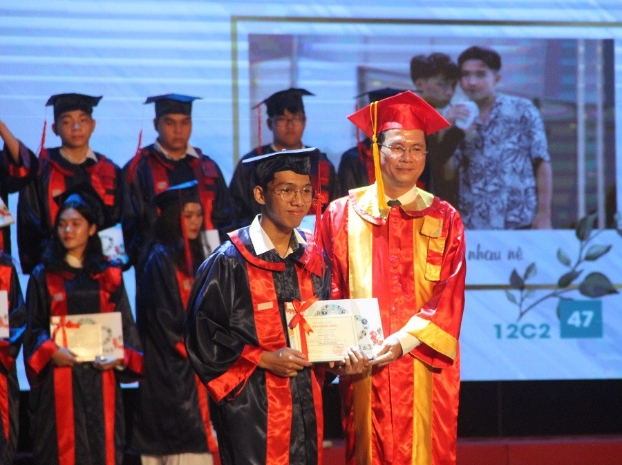 Thầy hiệu trưởng trao Học giấy chứng nhận hoàn thành chương trình lớp 12 cho học sinh