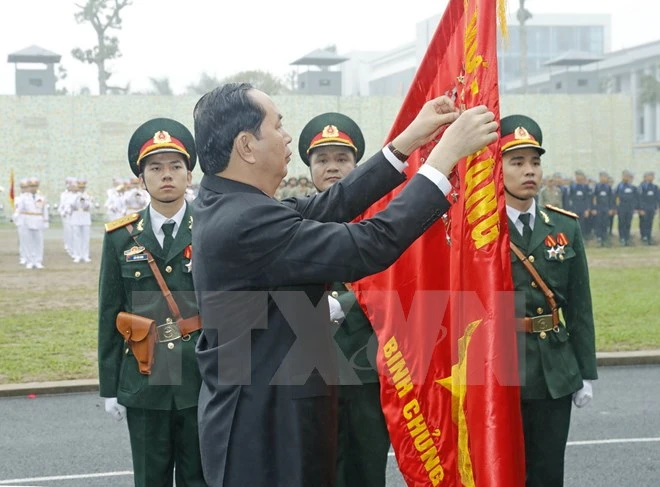 Chủ tịch nước Trần Đại Quang gắn Huân chương Quân công hạng Nhất lên lá cờ truyền thống của Bộ Tư lệnh Binh chủng Đặc công.Ảnh: TTXVN