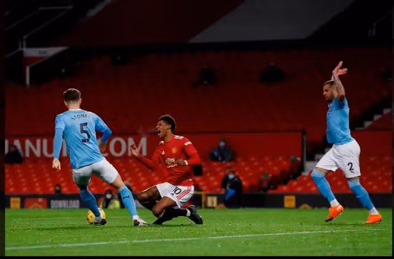 Rashford đau đớn sau khi bị Walker đốn ngã trong vòng cấm.