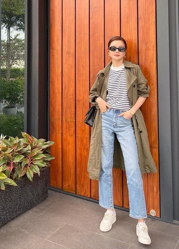 Thiều Bảo Trang diện áo kẻ ngang và trench coat dáng dài, phối thêm quần jeans và giày thể thao năng động, trẻ trung. Thiều Bảo Trang diện áo kẻ ngang và trench coat dáng dài, phối thêm quần jeans và giày thể thao năng động, trẻ trung.