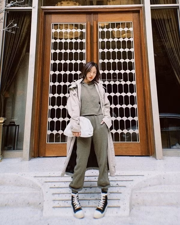 Văn Mai Hương diện trench coat ấm áp xuống phố ngày lạnh với phiên bản màu ghi sáng, phối cùng bộ thể thao tông rêu trầm và sneakers cao cổ. Chiếc clutch to bản là phụ kiện tạo nên vẻ độc đáo cho set đồ street style của nữ ca sĩ.
