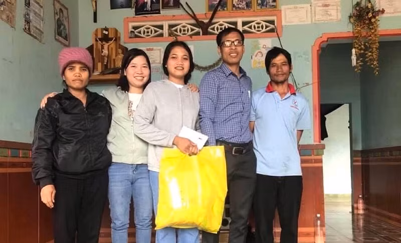 Thầy Nay A Yôn đến thăm và tặng quà cho học sinh khó khăn.