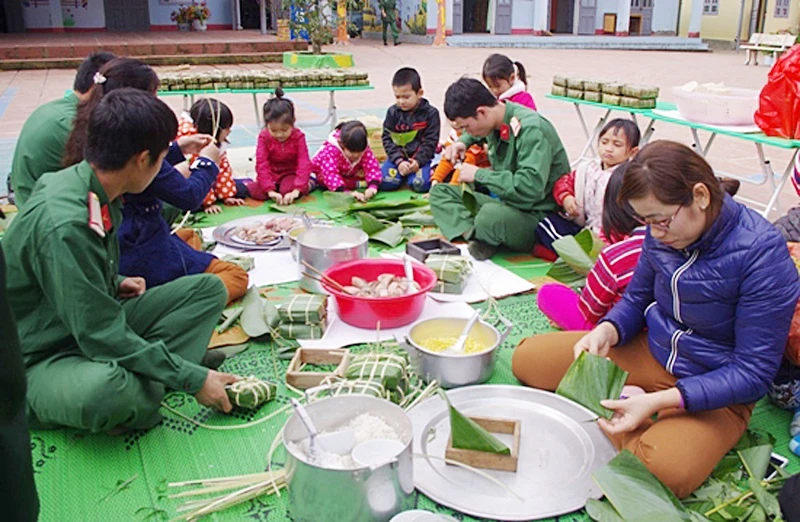 Chiến sĩ và giáo viên Trường Mầm non Núa Ngam (Điện Biên) gói bánh chưng tặng học sinh và hộ nghèo trên địa bàn.