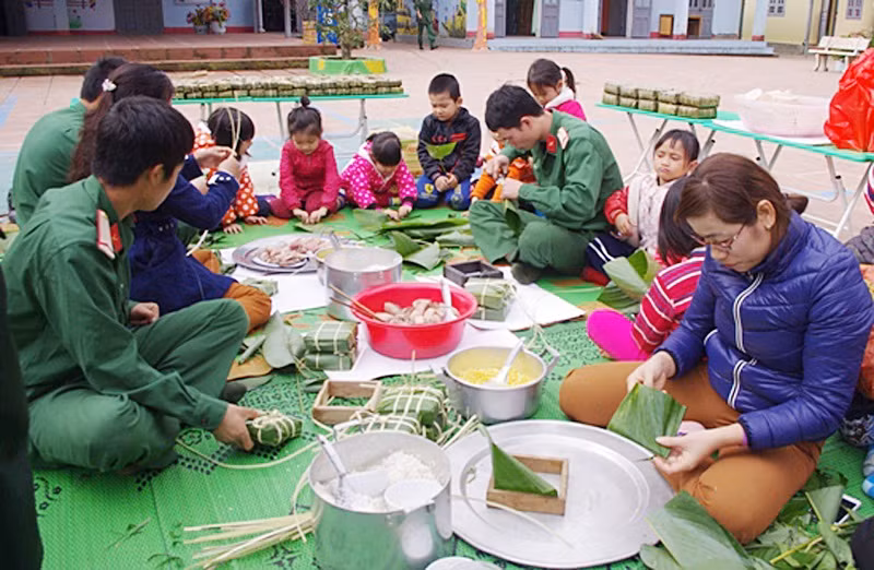 Chiến sĩ và giáo viên Trường Mầm non Núa Ngam (Điện Biên) gói bánh chưng tặng học sinh và hộ nghèo trên địa bàn.