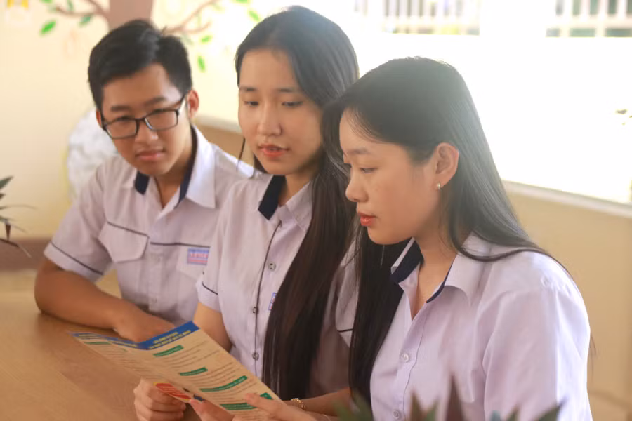 Học sinh TP Buôn Ma Thuột tìm hiểu thông tin về SKSS vị thành niên qua tờ rơi của ngành y tế. Ảnh: Thành Tâm