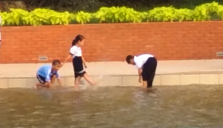 Nhiều trẻ thấy nước ngập lối đi nên nghịch nước (phía ngoài là khu vực hồ sâu) 