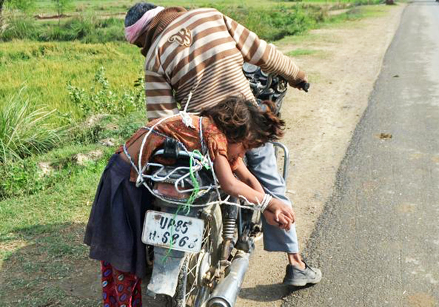 Ông bố Ấn Độ trói con vào xe chở đến trường. Ảnh: Getty Images. Ông bố Ấn Độ trói con vào xe chở đến trường. Ảnh: Getty Images.