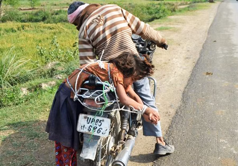 Ông bố Ấn Độ trói con vào xe chở đến trường. Ảnh: Getty Images. Ông bố Ấn Độ trói con vào xe chở đến trường. Ảnh: Getty Images.