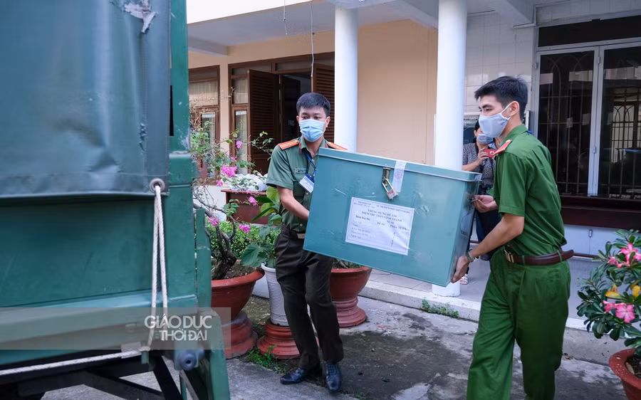 Cán bộ Công an đưa đề thi lên xe chuyên dụng.