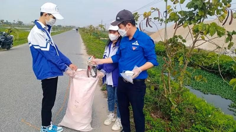 Học sinh Trường THCS Thái Thụy (Thái Bình) tham gia lao động nhặt khẩu trang, túi nilon bên đường giao thông.