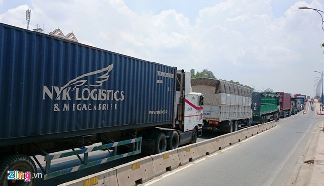 Dòng xe lớn xếp hàng qua cầu Giồng Ông Tố, hướng ra đại lộ Mai Chí Thọ. Cửa ngõ Sài Gòn kẹt xe hơn nửa ngày vẫn chưa thông