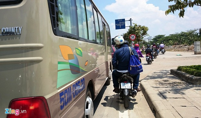 Người đi xe máy bị ôtô lấn hết đường lưu thông, phải chạy lên vỉa hè của đại lộ Mai Chí Thọ. Cửa ngõ Sài Gòn kẹt xe hơn nửa ngày vẫn chưa thông