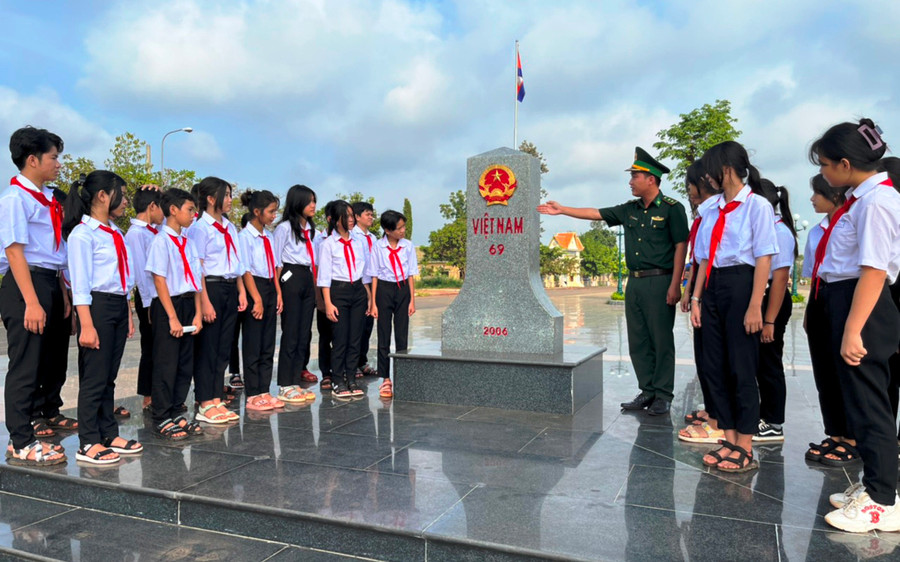 Học sinh Trường Tiểu học &amp; THCS Lộc Hòa nghe cán bộ Đồn Biên phòng cửa khẩu quốc tế Hoa Lư giới thiệu về ý nghĩa, lịch sử và cấu tạo của cột mốc.