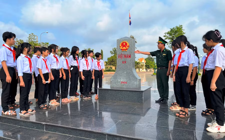 Học sinh Trường Tiểu học &amp; THCS Lộc Hòa nghe cán bộ Đồn Biên phòng cửa khẩu quốc tế Hoa Lư giới thiệu về ý nghĩa, lịch sử và cấu tạo của cột mốc.