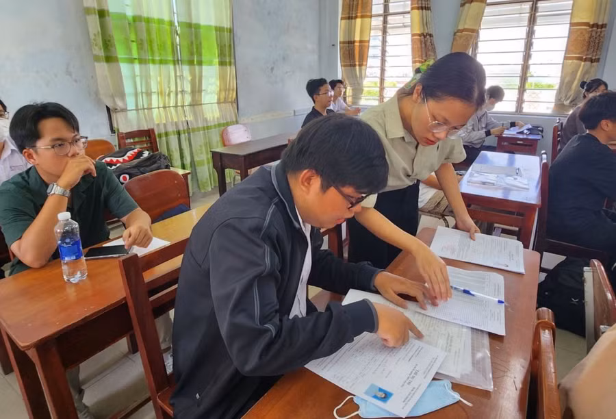 Cán bộ thi đối chiếu thông tin của thí sinh tại buổi phổ biến quy chế thi Kỳ thi tốt nghiệp THPT năm 2023 (điểm thi Trường THPT Phạm Phú Thứ, Đà Nẵng). Ảnh: PV