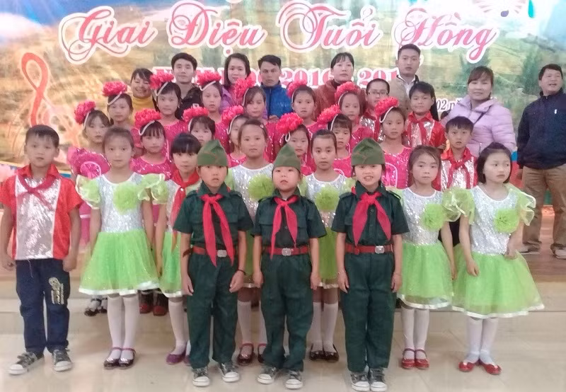 Cô Hoa và thầy Thái (thứ 3 và thứ 4 từ trái qua) chụp hình lưu niệm cùng các em học sinh.