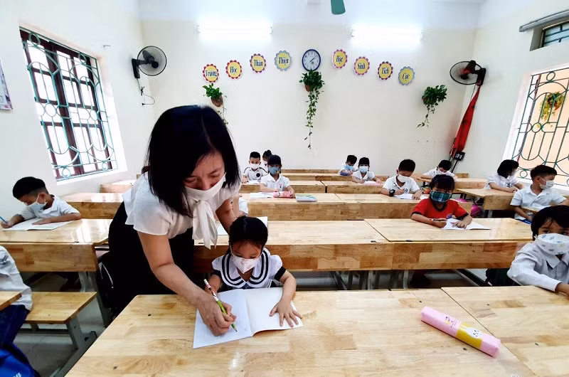 Học sinh lớp 1 được giáo viên trực tiếp nắn nét chữ khi đến trường.