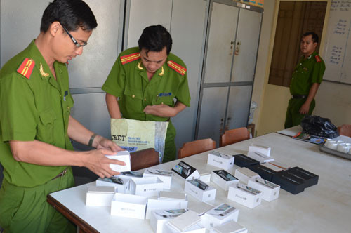 Công an đang kiểm tra vật chứng iPhone cục gạch. Ảnh: Thanh niên