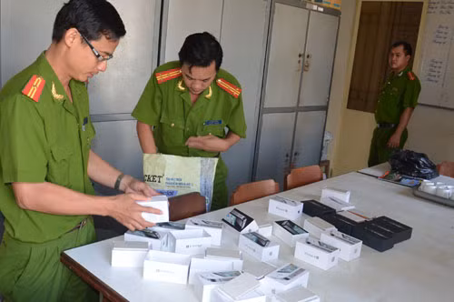 Công an đang kiểm tra vật chứng iPhone cục gạch. Ảnh: Thanh niên