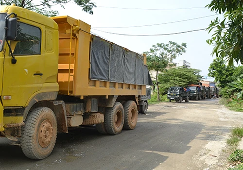 Hàng chục xe tải xếp hàng dài vì bị người dân dựng chướng ngại vật giữa đường. Ảnh: N.Đ