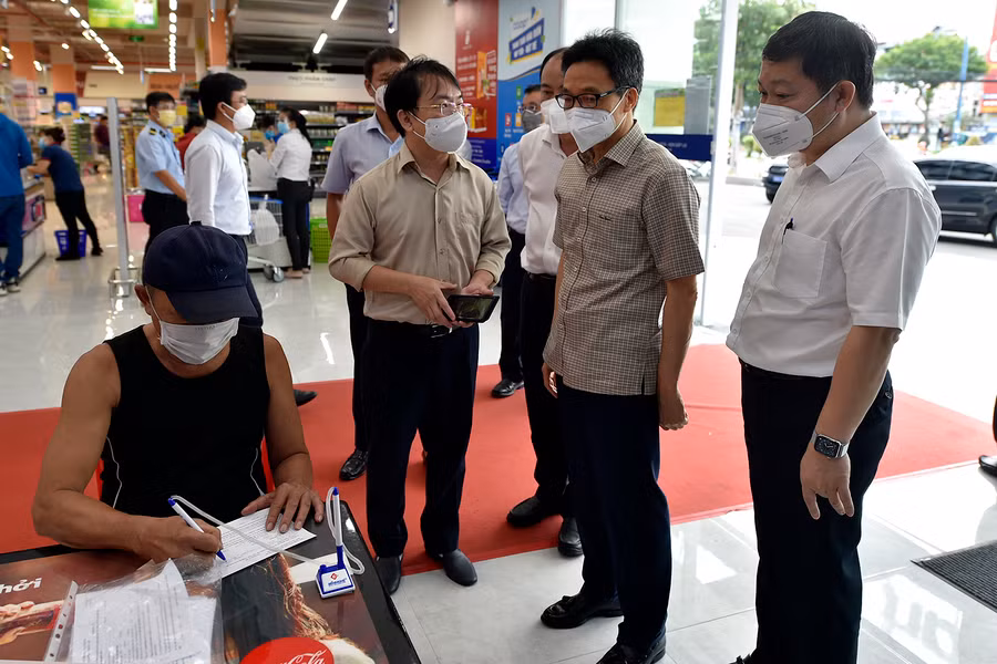 Ngoài việc thực hiện khai báo y tế bằng mã QR, những người không có điện thoại thông minh sẽ khai báo giấy và được siêu thị Coop mart nhập dữ liệu ngay lên hệ thống. Ảnh: VGP/Đình Nam