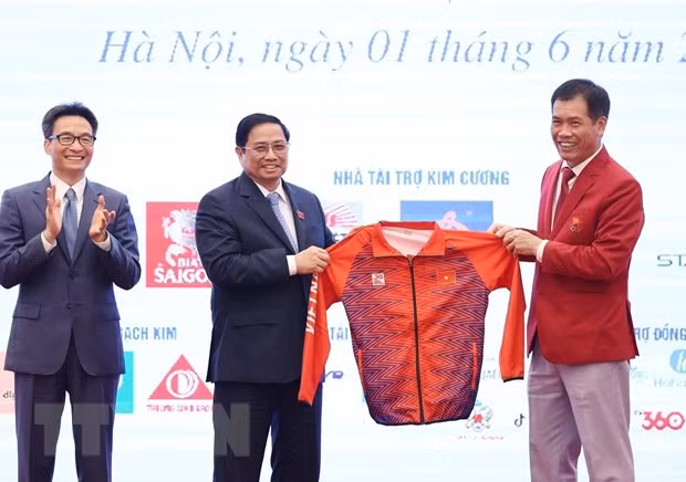 Đại diện Đoàn thể thao Việt Nam tặng lưu niệm cho Thủ tướng Phạm Minh Chính. (Ảnh: Dương Giang/TTXVN).