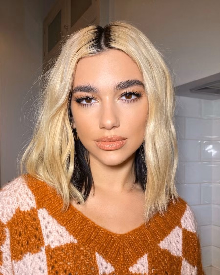 Nhuộm chừa rãnh đen: Dua Lipa được xem như "nữ hoàng màu tóc của năm 2020". Cô thay đổi màu tóc liên tục nhưng kiểu chừa rãnh vẫn để lại ấn tượng nhất. Nếu muốn tạo không khí nóng hơn cho những ngày cuối năm, bạn có thể làm kiểu này. Tuy nhiên, bạn cần chăm gội đầu bởi tóc bết dễ khiến vẻ ngoài trông luộm thuộm. Ảnh: @nikki_makeup.